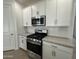 Kitchen detail showcasing stainless steel range, microwave and white cabinetry with modern hardware at 22859 E Lords Way, Queen Creek, AZ 85142