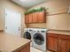 Laundry room with washer, dryer, and wooden cabinets at 2602 W Trapanotto Rd, Phoenix, AZ 85086