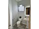 Stylish powder room featuring a pedestal sink, patterned tile floors and a unique window at 28414 N 101St Pl, Scottsdale, AZ 85262