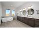 Elegant bathroom with double vanity, free-standing tub, and large mirrors at 29456 N 208Th Ln, Wittmann, AZ 85361