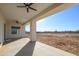 Large covered patio with ceiling fans and views of the desert landscape at 29456 N 208Th Ln, Wittmann, AZ 85361