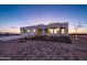 Modern three-car garage home with desert landscaping at sunset at 29456 N 208Th Ln, Wittmann, AZ 85361