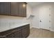 Laundry room with dark cabinets and quartz countertops at 29456 N 208Th Ln, Wittmann, AZ 85361