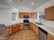 Modern kitchen with wood cabinets, stainless steel appliances, and tile flooring at 31027 W Bellview St, Buckeye, AZ 85396