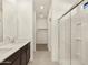 Bathroom featuring dual sinks, white countertops, dark cabinets and a glass shower enclosure at 37042 W Prado St, Maricopa, AZ 85138