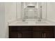 Bathroom featuring a dual sink vanity, white countertops, dark cabinets and a glass shower at 37042 W Prado St, Maricopa, AZ 85138