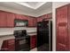 Modern kitchen with dark wood cabinets and a black refrigerator at 3830 E Lakewood Pkwy # 1114, Phoenix, AZ 85048