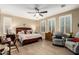 Main bedroom with sitting area, wood bed frame, and ceiling fan at 39725 N Hailey Ln, San Tan Valley, AZ 85140