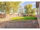 Landscaped backyard with grassy area and trees at 44562 W Sedona Trl, Maricopa, AZ 85139