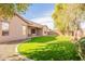 Large backyard with grassy lawn, bordered by trees and a gravel pathway at 44562 W Sedona Trl, Maricopa, AZ 85139