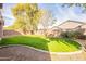 Landscaped backyard with grassy area and trees at 44562 W Sedona Trl, Maricopa, AZ 85139