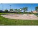 Outdoor basketball court with benches, surrounded by grass at 44562 W Sedona Trl, Maricopa, AZ 85139