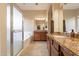 Double vanity bathroom with granite counters and a shower at 44562 W Sedona Trl, Maricopa, AZ 85139