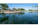 Scenic community lake with playground and palm trees at 44562 W Sedona Trl, Maricopa, AZ 85139