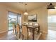 Bright dining room, staged with modern furniture, and backyard access at 44562 W Sedona Trl, Maricopa, AZ 85139