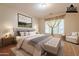 Virtually staged main bedroom with plush bedding and seating at 44562 W Sedona Trl, Maricopa, AZ 85139