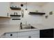 Clean kitchen with white cabinets, floating shelves, and a farmhouse sink at 4754 N 14Th St, Phoenix, AZ 85014