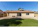 Spacious backyard with artificial turf and sliding glass door access at 6207 W Acoma Dr, Glendale, AZ 85306