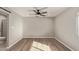 Well-lit bedroom with wood-look floors and ceiling fan at 6207 W Acoma Dr, Glendale, AZ 85306