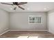 Light bedroom with window, ceiling fan and laminate floor at 6207 W Acoma Dr, Glendale, AZ 85306