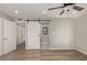 Bedroom with barn door to en-suite bathroom and laminate floor at 6207 W Acoma Dr, Glendale, AZ 85306