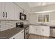 Modern kitchen with white cabinets, gray countertops and stainless steel appliances at 6207 W Acoma Dr, Glendale, AZ 85306