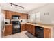 Kitchen with wood cabinets and black appliances at 6538 W Nez Perce St, Phoenix, AZ 85043