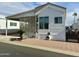 White single-wide manufactured home with covered porch and screened patio at 7750 E Broadway Rd # 232, Mesa, AZ 85208