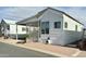 White single-wide manufactured home with covered porch and screened patio at 7750 E Broadway Rd # 232, Mesa, AZ 85208