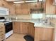 Galley kitchen with light wood cabinets, and an electric range at 7750 E Broadway Rd # 232, Mesa, AZ 85208