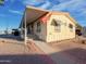 Tan mobile home with carport and small front yard at 8600 E Broadway Rd # 91, Mesa, AZ 85207