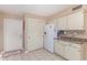 White kitchen cabinets and appliances with tile floor at 910 S Portland Cir, Mesa, AZ 85206