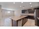 Modern kitchen with island, stainless steel appliances, and dark cabinetry at 9925 E Orange Grove St, Florence, AZ 85132