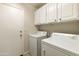 Laundry room with washer, dryer, and upper cabinets at 11111 E Elmhurst Dr, Sun Lakes, AZ 85248