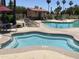 Community pool and spa with lounge chairs and landscaping at 11111 E Elmhurst Dr, Sun Lakes, AZ 85248