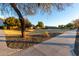 Community walking path with mature trees and grassy areas at 1127 S 165Th Dr, Goodyear, AZ 85338