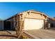 Tan house with a two-car garage and drought-tolerant landscaping at 1127 S 165Th Dr, Goodyear, AZ 85338