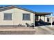 Tan single-wide manufactured home with carport and paved driveway at 11275 N 99Th Ave # 7, Peoria, AZ 85345