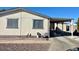 Tan single-wide manufactured home with carport and paved driveway at 11275 N 99Th Ave # 7, Peoria, AZ 85345