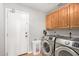 Laundry room with washer, dryer, and wood cabinets at 1201 E Campbell Ave, Gilbert, AZ 85234