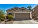 Tan house with a two-car garage and desert landscaping at 12443 W Via Camille Dr, El Mirage, AZ 85335