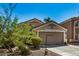 Tan house with a two-car garage and mature trees at 12443 W Via Camille Dr, El Mirage, AZ 85335