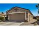 Tan house with a two-car garage and side yard view at 12443 W Via Camille Dr, El Mirage, AZ 85335