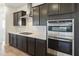 Stainless steel appliances and dark brown cabinets in this kitchen at 19028 W Rose Ln, Waddell, AZ 85355