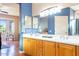 Bathroom with double sinks, wood cabinets, and a large mirror at 19612 N Wasson Peak Dr, Surprise, AZ 85387