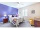 Purple-accented bedroom with a queen bed and ceiling fan at 19612 N Wasson Peak Dr, Surprise, AZ 85387