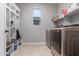 Bright laundry room, featuring washer, dryer, and built-in storage at 19690 W Marshall Ave, Litchfield Park, AZ 85340