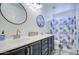 Double vanity bathroom with dark cabinets and geometric shower curtain at 20997 N 79Th Ave, Peoria, AZ 85382