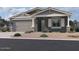 One-story home with gray siding, stone accents, and a two-car garage at 22851 E Lords Way, Queen Creek, AZ 85142