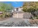 Two-story house with beige exterior, two-car garage, and desert landscaping at 2542 W Kit Carson Trl, Phoenix, AZ 85086